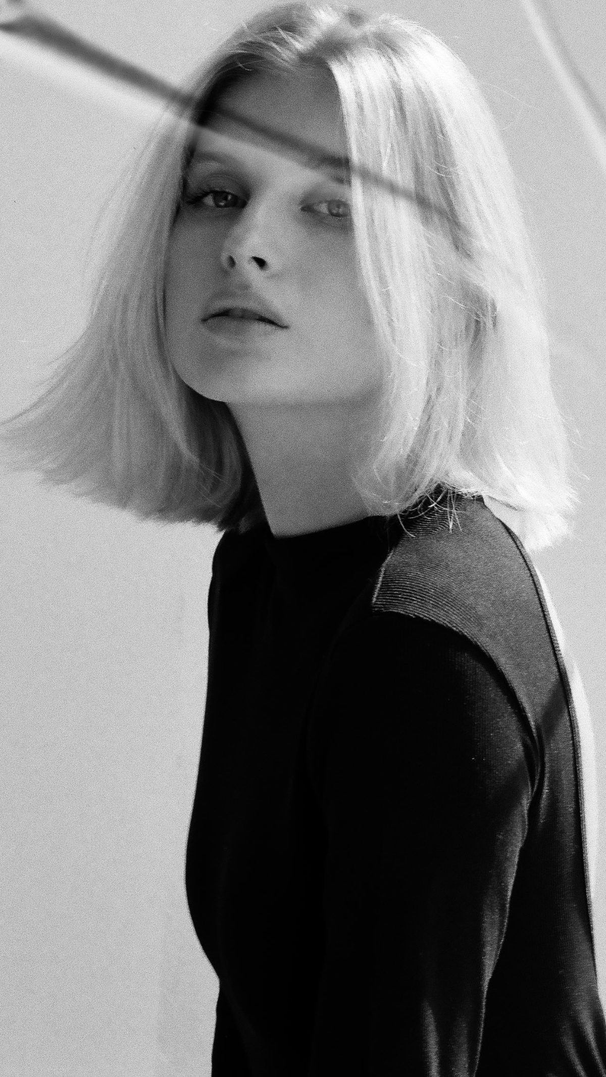 Portrait en noir et blanc d’une femme blonde au teint clair, coupe au carré.